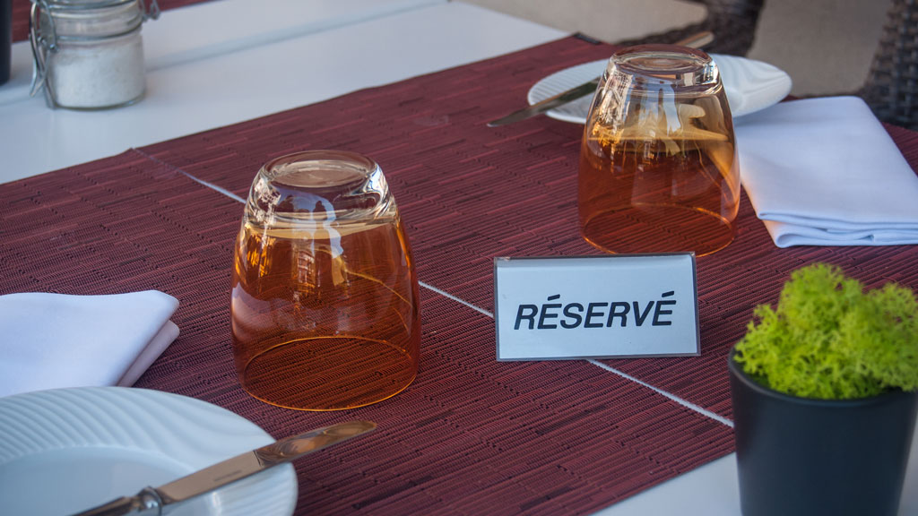 Consultation de la carte d'un restaurant gastronomique de Talloires sur smartphone en terrasse