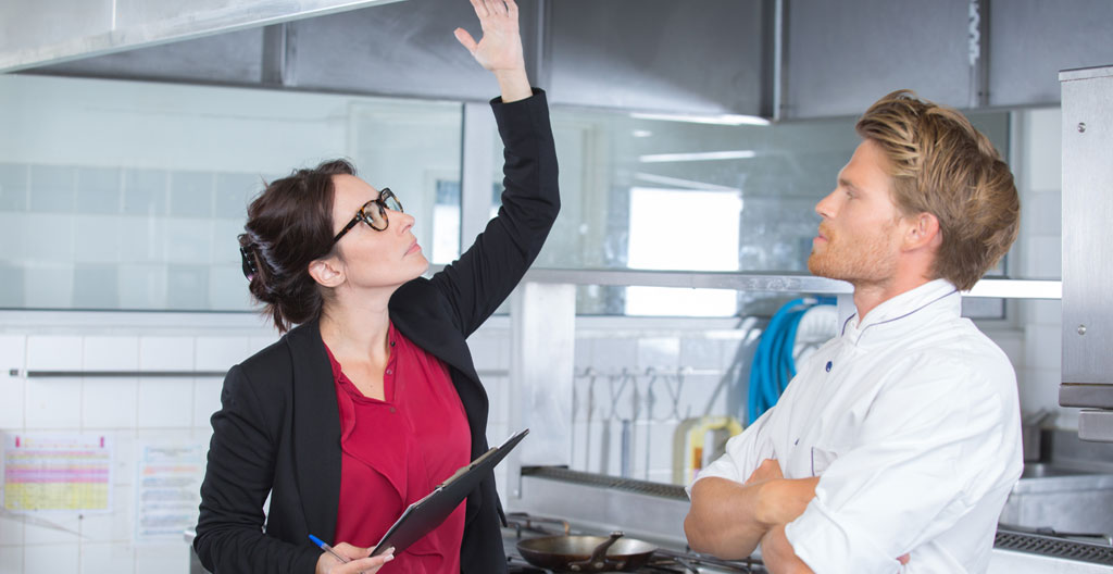 Inspecteur sanitaire et restaurateur consultant un classeur de documents de traçabilité