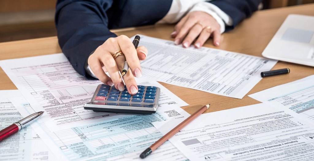 Documents fiscaux français et calculatrice disposés sur bureau moderne pour optimisation placements